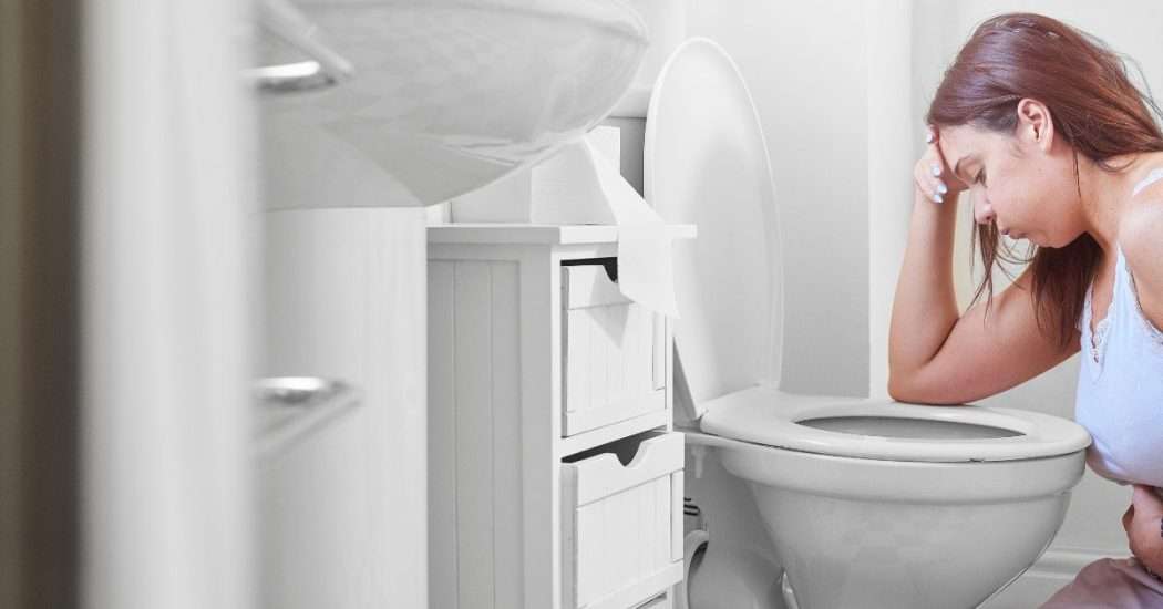 Morning Sickness Remedies. Image of woman leaned over toilet.