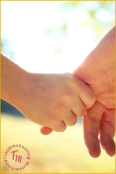 The most important life skills to teach your kids. Image of parent and child holding hands.