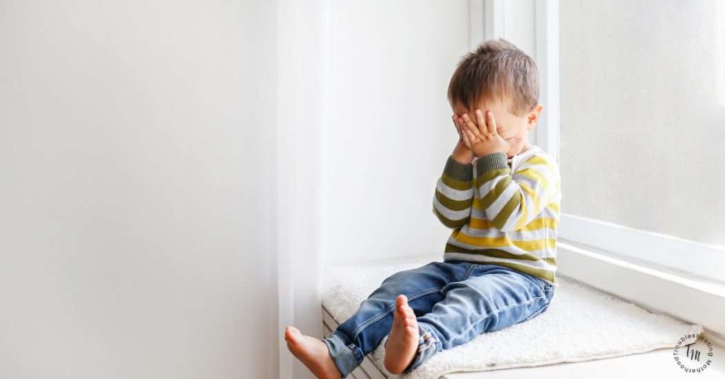 Toddler Power Struggle. Image of toddler on window seat, hands covering his eyes. Toddler Parenting.
